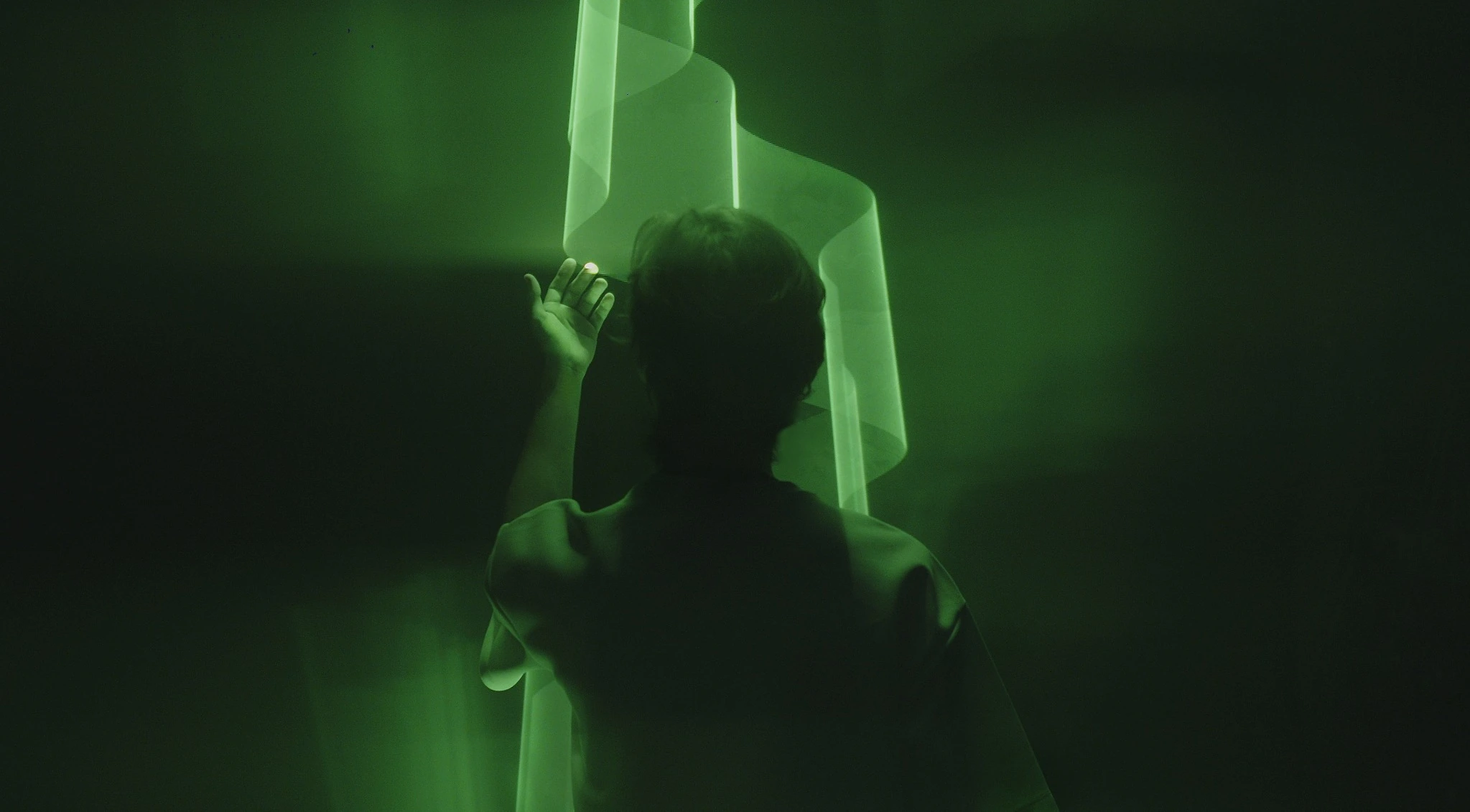 BOREAL — figura humana diante de uma membrana verde de luz